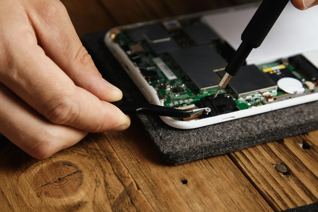 Technician performing professional iPad screen repair with precision tools in a service center