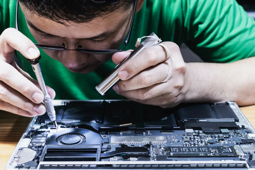 Professional repair technician diagnosing laptop hardware issues