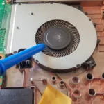 Laptop cooling system failure showing dust buildup and overheating fan inside laptop