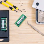 Laptop RAM upgrade guide showing technician installing memory module into laptop