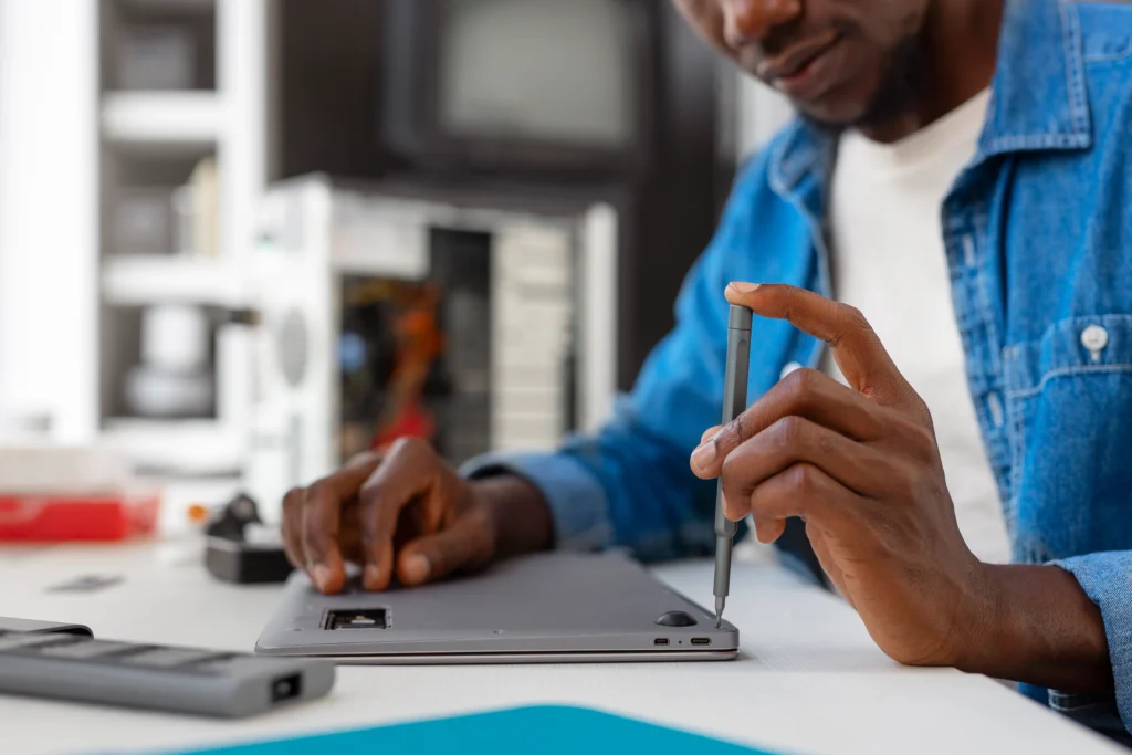Technician performing laptop screen repair and replacing a damaged display panel