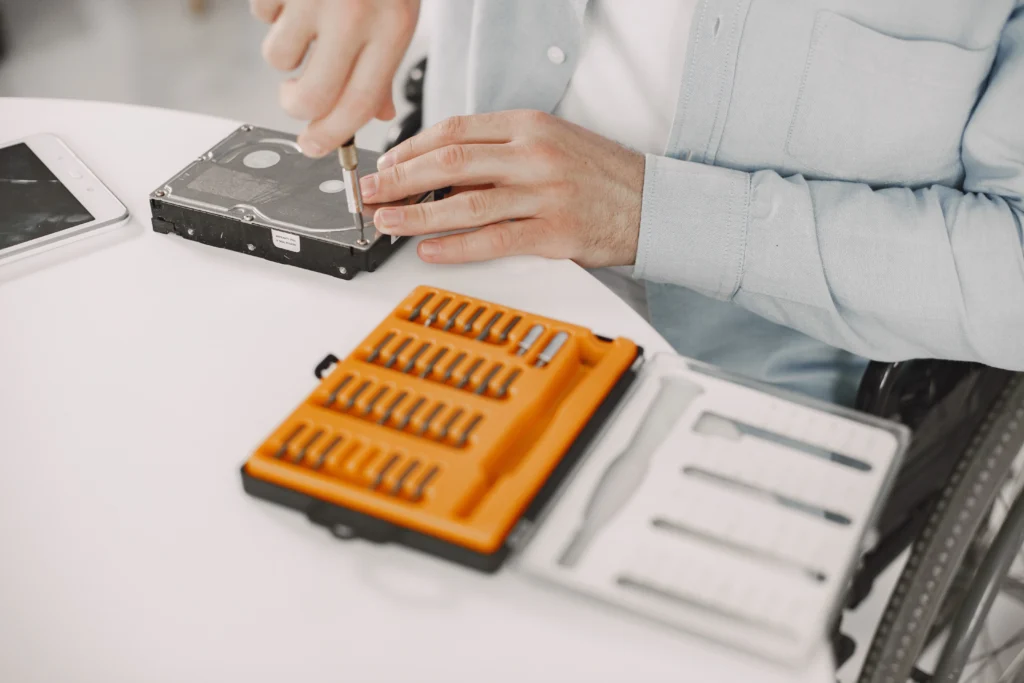 Technician performing laptop data recovery on a dead hard drive to restore lost files.